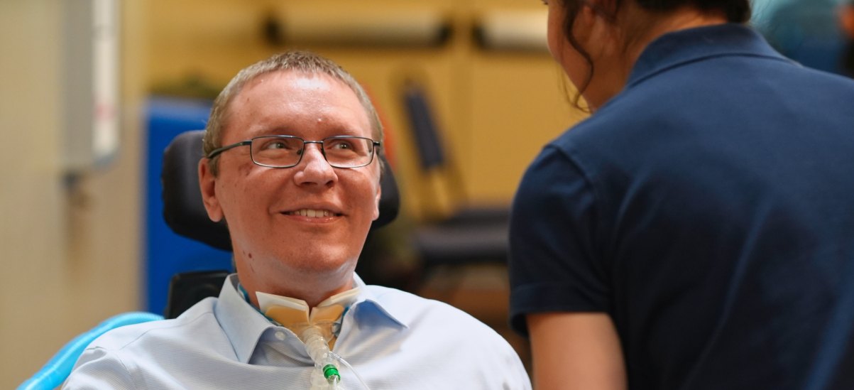 An INCIGHT community member smiling in conversation with a supporter.