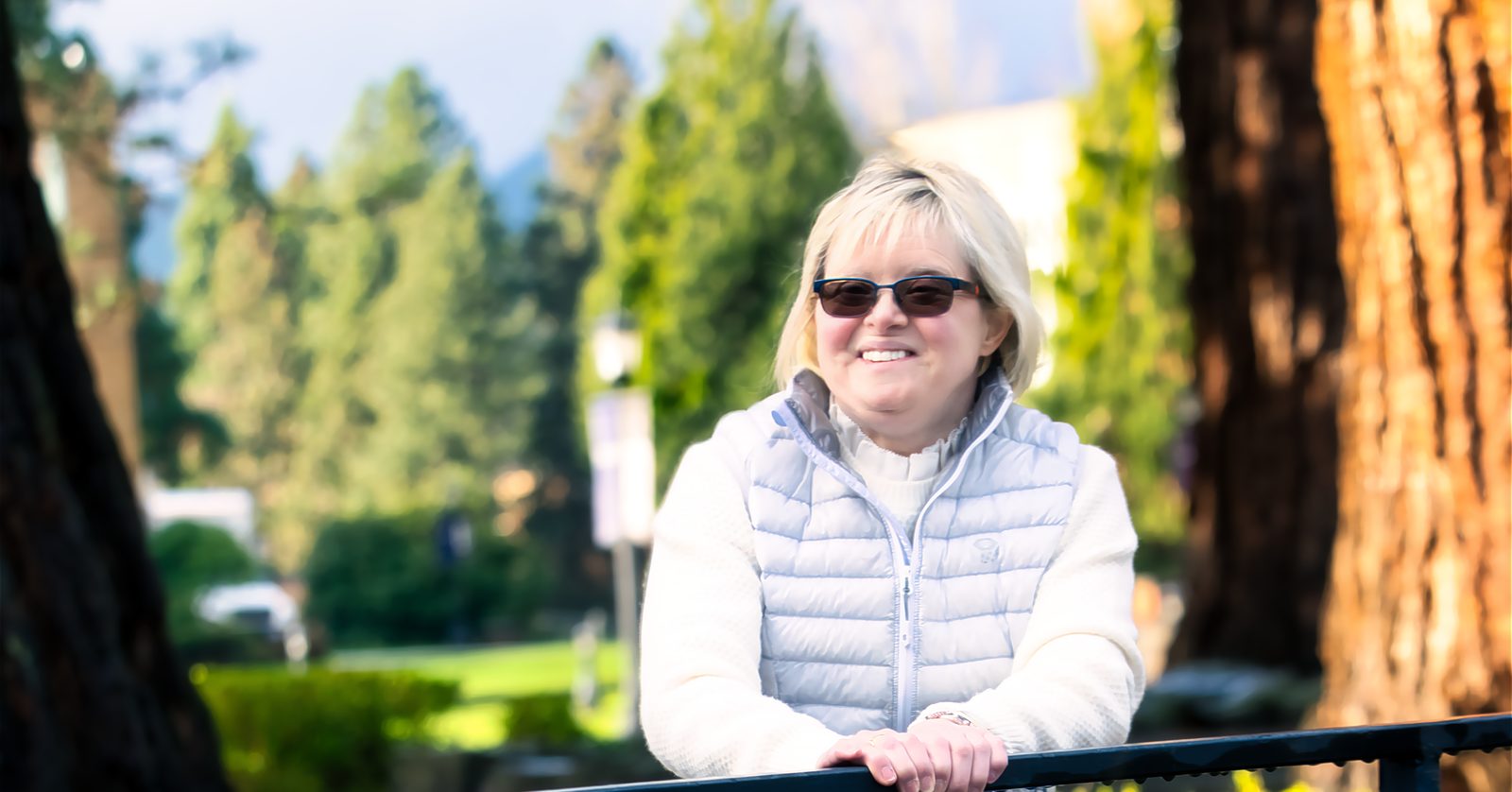 Karen Gaffney outdoors, leaning on a handrail in the sunshine.